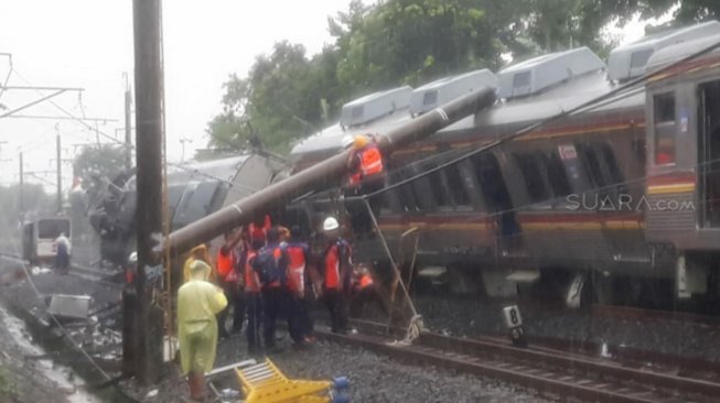 Petugas mengevakuasi KRL Commuter Line 1722 yang anjlok di pintu perlintasan Kebon Pedes, Tanah Sareal, Bogor, Jawa Barat, Minggu (10/3). [Suara.com/Novian Ardiansyah]