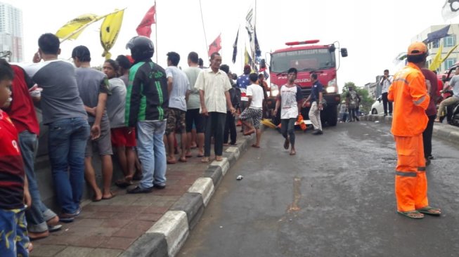 Warga melihat proses pemadaman kapal nelayan yang terbakar di Pelabuhan Muara Angke, Jakarta Utara. (Foto dok. petugas)