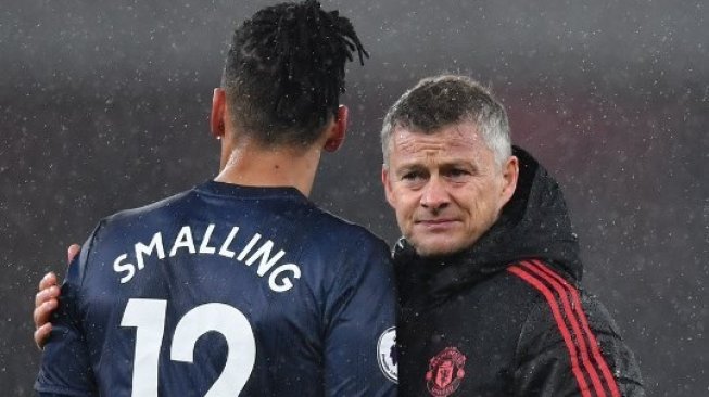 Manajer Manchester United Ole Gunnar Solskjaer (kanan) menenangkan bek Chris Smalling (kiri) usai dikalahkan Arsenal di Emirates Stadium. Ben STANSALL / AFP