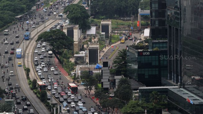 Kendaraan melintas di sekitar Bundaran Hotel Indonesia (HI), Jakarta, Selasa (12/3). [Suara.com/Arief Hermawan P.]