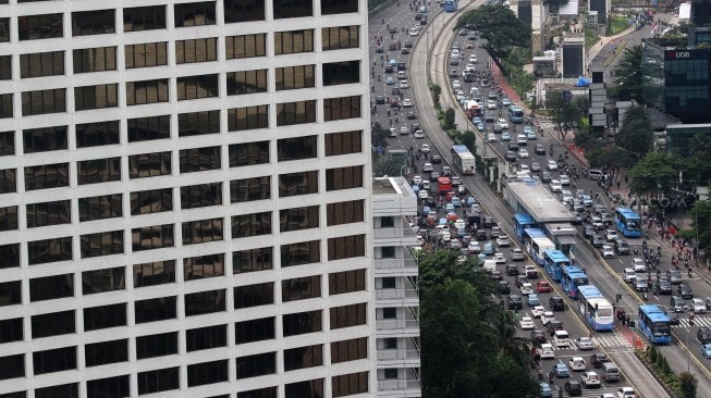 Kendaraan melintas di sekitar Bundaran Hotel Indonesia (HI), Jakarta, Selasa (12/3). [Suara.com/Arief Hermawan P.]