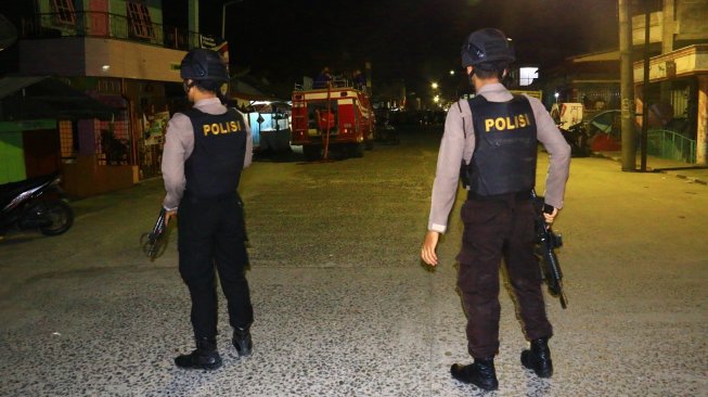 Polisi bersenjata berjaga di lokasi terjadinya ledakan yang diduga bom saat penggerebekan terduga teroris di kawasan Jalan KH Ahmad Dahlan, Pancuran Bambu, Sibolga Sambas, Kota Sibolga, Sumatera Utara, Selasa (12/3/2019). [Antara/Jason Gultom]