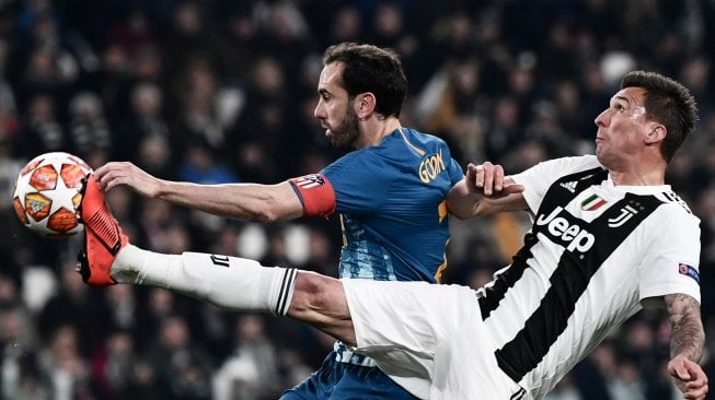 Bek Atletico Madrid, Diego Godin memperebutkan bola dengan pemain depan Juventus Mario Mandzukic pada pertandingan leg kedua babak 16 besar Liga Champions antara Juventus  melawan Atletico Madrid di Allianz Stadium, Turin, Italia, Rabu (13/3) dini hari WIB. [Marco BERTORELLO / AFP]
