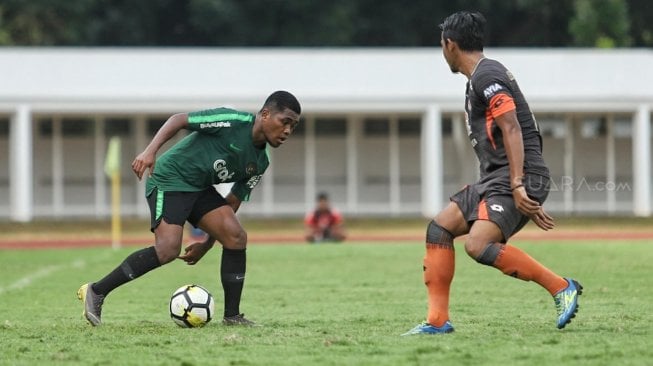 Pemain Timnas Indonesia U-23 mencoba melewati pemain Semen Padang dalam laga uji coba di Stadion Madya, Kompleks Gelora Bung Karno, Senayan, Jakarta, Selasa (12/3). [Suara.com/Muhaimin A Untung]