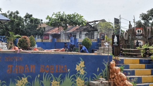 

Petugas Dinas Sumber Daya Air DKI Jakarta menyelesaikan pembangunan Taman Robika di Pintu Air Manggarai, Jakarta, Kamis (14/3). [Suara.com/Muhaimin A Untung]