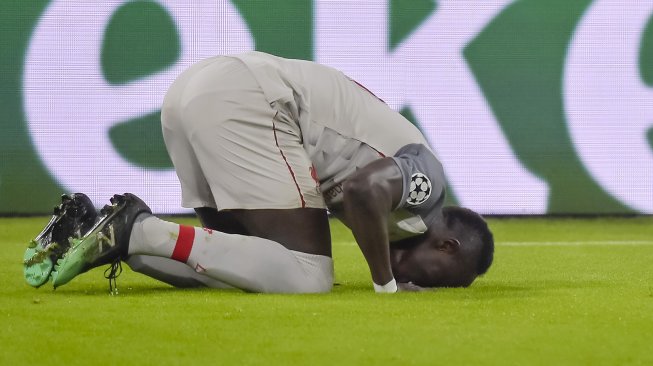 Striker Liverpool Sadio Mane merayakan golnya usai mencetak gol pembuka selama pertandingan leg kedua babak 16 besar Liga Champions antara Bayern Munchen melawan Liverpool di Allianz Arena, Munich, Jerman, Kamis (14/3) dini hari WIB. 
[SCHENFMANN GUENTER / AFP]