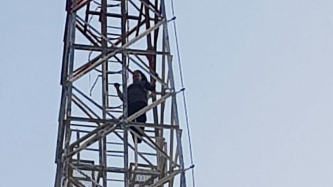 Penampakan Ria saat menaiki tower untuk mencoba bunuh diri. (dok. polisi)