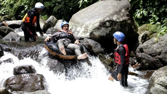 Wisatawan menikmati wisata tubing atau menyusuri sungai memanfaatkan ban dalam mobil yang digelar Sukabumi Getlost di Sungai Cipelang, Sukabumi, Jawa Barat, Kamis (14/3). ANTARA FOTO/Budiyanto