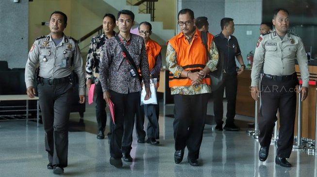 Kepala Kantor Wilayah Kemenag Jawa Timur Haris Hasanuddin dan Kepala Kantor Kemenag Kabupaten Gresik Muhammad Muafaq Wirahadi mengenakan rompi tahanan seusai menjalani pemeriksaan pasca OTT di gedung KPK, Jakarta, Sabtu (16/3). [Suara.com/Muhaimin A Untung]