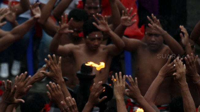 Penari menampilkan tari kecak di Pura Uluwatu, Bali, Minggu (17/3).  [Suara.com/Oke Atmaja]