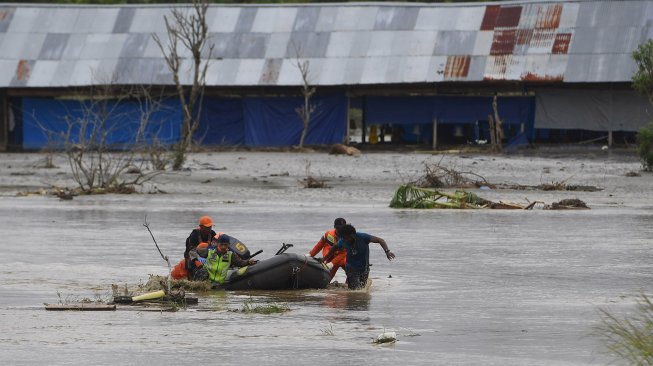 Tim SAR Gabungan mendorong perahu karet yang memuat jenazah korban banjir bandang Sentani yang di temukan di sekitar perumahan Gajah Mada di Sentani, Jaya Pura, Papua, Selasa (19/3). [ANTARA FOTO/Zabur Karuru]