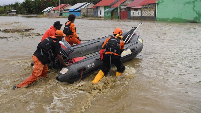 Anggota Basarnas mendorong perahu karet ketika melakukan evakuasi jenazah korban banjir bandang Sentani yang di temukan di sekitar perumahan Gajah Mada di Sentani, Jaya Pura, Papua, Selasa (19/3). [ANTARA FOTO/Zabur Karuru]