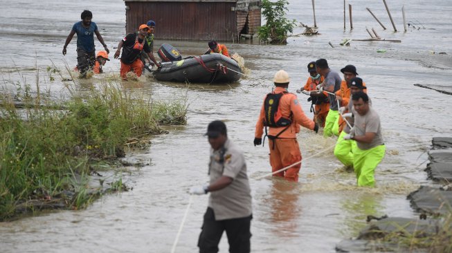 Tim SAR Gabungan mendorong perahu karet yang memuat jenazah korban banjir bandang Sentani yang di temukan di sekitar perumahan Gajah Mada di Sentani, Jaya Pura, Papua, Selasa (19/3). [ANTARA FOTO/Zabur Karuru]