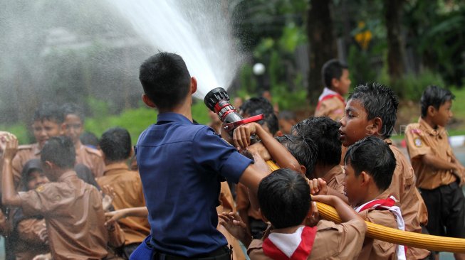 Petugas Suku Dinas Pemadam Kebakaran (Damkar) Jakarta Selatan bersama sejumlah siswa melakukan simulasi pemadaman kebakaran di SDN Kebagusan 01 Pagi, Rabu (20/3). [Suara.com/Arief Hermawan P]