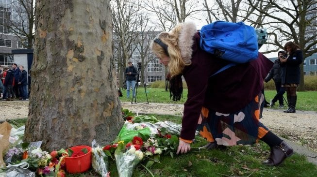 Seorang wanita meletakkan bunga di lokasi penembakan di trem Kota Utrecht, Belanda. (AFP)