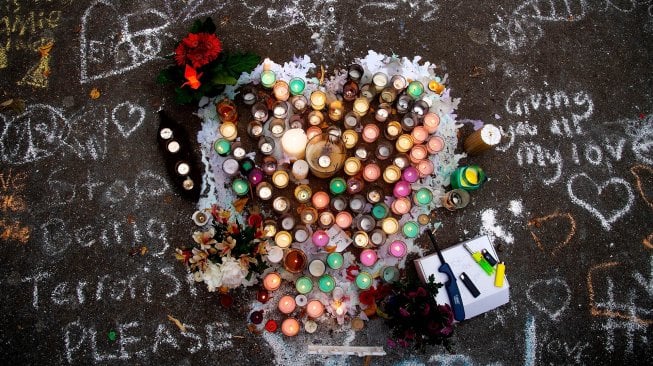 Para warga kota Christchurch meletakan bunga di dinding depan Botanical Garden, Selandia Baru, Selasa (19/3).  [Marty MELVILLE / AFP]