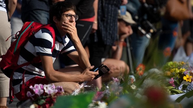 Para warga kota Christchurch meletakan bunga di dinding depan Botanical Garden, Selandia Baru, Selasa (19/3).  [Marty MELVILLE / AFP]