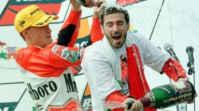 Max Biaggi (kanan) merayakan keberhasilannya menjadi juara dunia kelas 250cc 1997 bersama rekan setimnya Ralf Waldmann. [AFP/Torsten Blackwood]
