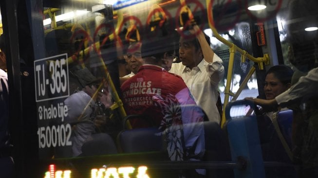 Presiden Joko Widodo didampingi Ibu Negara Iriana Joko Widodo menaiki bus Transjakarta menuju Stasiun MRT Bundaran Hotel Indonesia di Jakarta, Kamis (21/3). ANTARA FOTO / Puspa Perwitasari