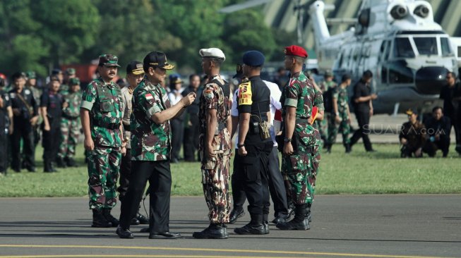 Menko Polhukam Wiranto bersama Panglima TNI Marsekal Hadi Tjahjanto saat mengikuti Apel Pengaman Pemilu Serentak 2019 di Lanud Halim Perdanakusuma, Jakarta Timur, Jumat (22/3). [Suara.com/Muhaimin A Untung]