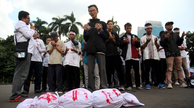 Sejumlah aktivis yang tergabung dalam Kesatuan Aksi Mahasiswa Muslim Indonesia (KAMMI) berunjuk rasa di kawasan Monas, Jakarta, Jumat (22/3). [Suara.com/Arief Hermawan P]