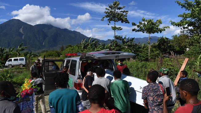 Keluarga duka mengangkat peti yang berisi jenazah korban banjir bandang Sentani ke dalam mobil jenazah untuk dimakamkan di Sentani, Jayapura, Papua, Sabtu (23/3).  [ANTARA FOTO/Zabur Karuru]