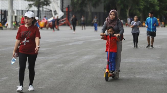 Warga berolahraga di kawasan Stadion Utama Gelora Bung Karno, Senayan, Jakarta, Minggu (24/3). [Suara.com/Muhaimin A Untung]