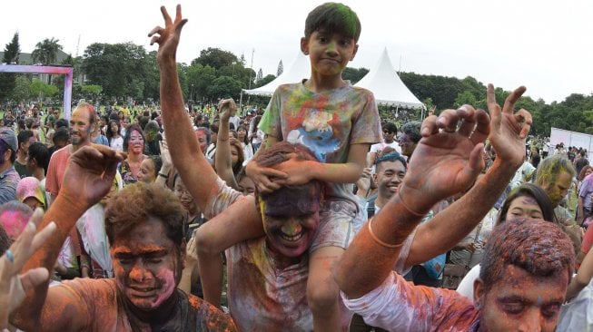 Sejumlah warga dan wisatawan menari saat Festival Holi di Denpasar, Bali, Sabtu (23/3). ANTARA FOTO/Fikri Yusuf