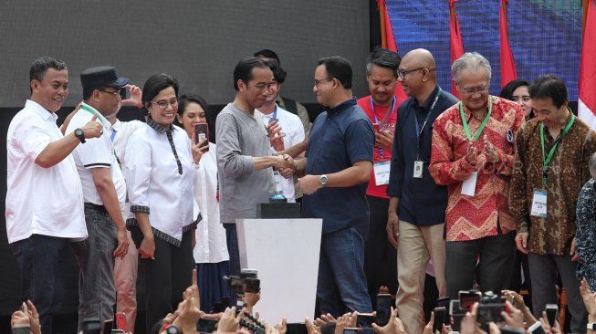 Presiden Joko Widodo bersalaman dengan Gubernur DKI Jakarta Anies Baswedan usai acara Peresmian MRT Jakarta, di kawasan Bundaran HI, Jakarta, Minggu (24/3). [Suara.com/Muhaimin A Untung]