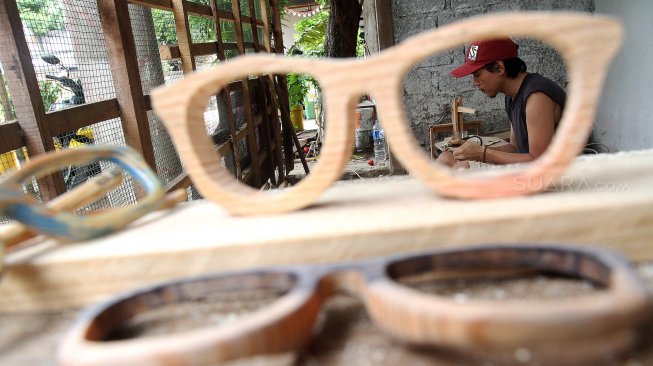 Pengrajin menyelesaikan pembuatan kacamata berbahan baku kayu di Jalan Salak 8, Pondok Benda, Pamulang, Tangerang Selatan, Senin (25/3). [Suara.com/Arief Hermawan 