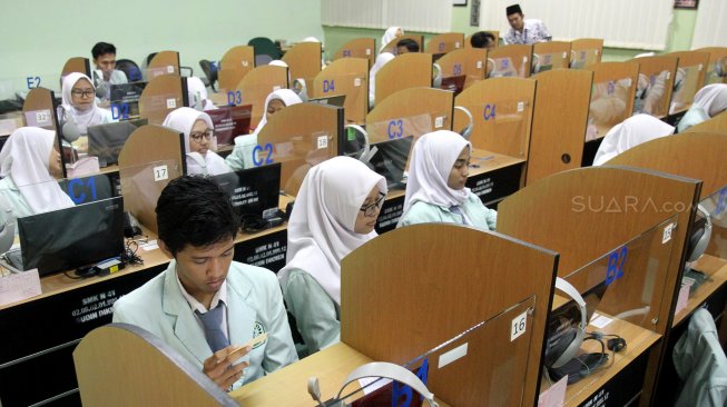 Sejumlah pelajar Sekolah Menengah Kejuruan (SMK) mengikuti Ujian Nasional Berbasis Komputer (UNBK) di SMK N 41 Jakarta, Cilandak, Jakarta (25/3). [Suara.com/Arief Hermawan P]