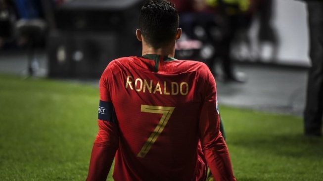 Bintang Portugal Cristiano Ronaldo terduduk di lapangan setelah mendapatkan cedera saat menghadapi Serbia di kualifikasi Piala Eropa 2020 di Luz stadium. PATRICIA DE MELO MOREIRA / AFP