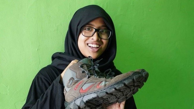 Nur Dhania menunjukkan sepatu yang dikenakannya saat kabur dari ISIS di Suriah. (Foto: Ari Wu / ABC News)