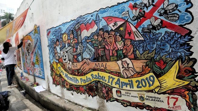 Seniman menggambar mural di kawasan Sudirman, Jakarta, Minggu (31/3). [Suara.com/Muhaimin A Untung]