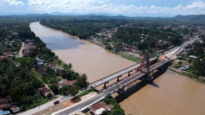 Sejumlah kendaraan melintasi Jembatan Sungai Dareh lama di samping Jembatan Sungai Dareh baru yang masih dalam proses pembangunan di Jalan Lintas Sumatera Sumbar-Jambi, Pulau Punjung, Dharmasraya, Sumatera Barat, Sabtu (30/3). ANTARA FOTO/Wahdi Septiawan