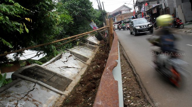 Kendaraan melintasi tembok yang roboh di Jalan Kebagusan Raya, Jakarta Selatan, Kamis (4/4). [Suara.com/Arief Hermawan P]
