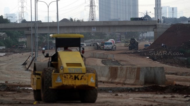 Pekerja menyelesaikan proyek jalan tol Desari seksi 2 Brigif-Sawangan di kawasan Depok, Jawa Barat, Jumat (5/4). [Suara.com/Arief Hermawan P]