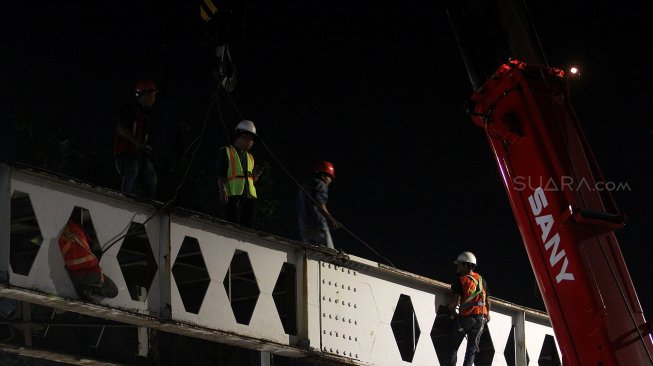 Suasana perobohan Jembatan Penyeberangan Orang (JPO) di depan Stasiun Pasar Minggu, Jakarta, Sabtu (6/4) dini hari. [Suara.com/Arief Hermawan P]