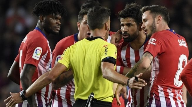 Striker Atletico Madrid, Diego Costa (kedua dari kanan) berbicara dengan wasit Gil Manzano pada laga jornada ke-31 Liga Spanyol 2018/2019 kontra Barcelona di Camp Nou, Minggu (7/4/2019) dini hari WIB. [LLUIS GENE / AFP]