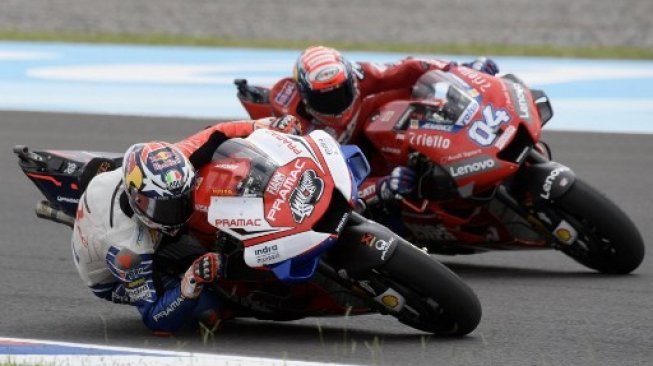 Pebalap tim satelit Ducati, Jack Miller (kiri), mencoba melewati rider utama Ducati, Andrea Dovizioso, saat sesi kualifikasi MotoGP Argentina, Sabtu (30/3/2019). [AFP/Juan Mabromata]