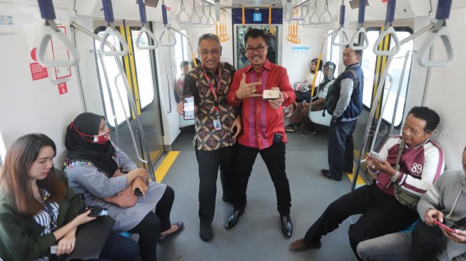 Deputy CEO Smartfren Djoko Tata Ibrahim dan VP Technology Relations and Special Project Smartfren Munir Syahda Prabowo mensosialisasikan kepada warga penggunaan kartu smartfren di MRT jakarta, Selasa (9/4). [Suara.com/Muhaimin A Untung]