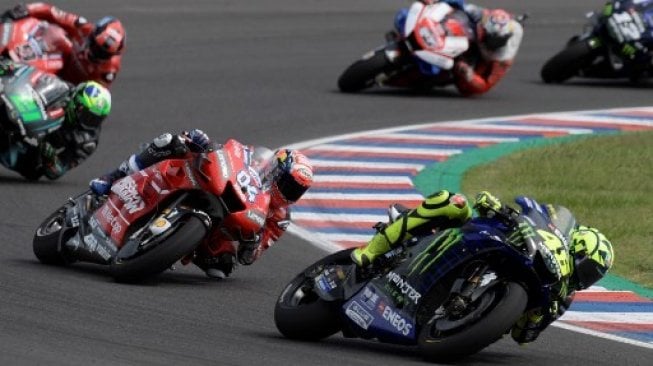 Pebalap Ducati Andrea Dovizioso menguntit kompatriotnya dari Italia, Valentino Rossi (Yamaha), saat balapan MotoGP Argentina di Autodromo Termas de Rio Hondo, Minggu (31/4/2019). [AFP/Juan Mabromata]