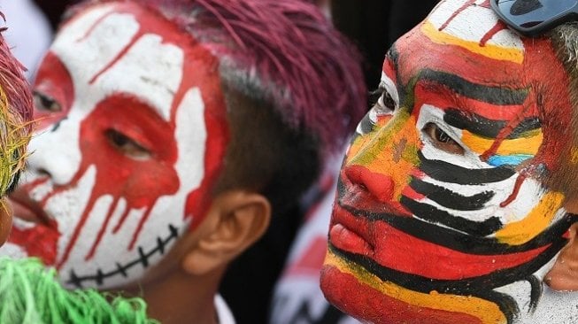 Simpatisan mengecat muka ketika mengikuti kampanye akbar yang dihadiri calon Presiden nomor urut 01 Joko Widodo di Solo, Jawa Tengah, Selasa (9/4/2019). (Foto: Antara)