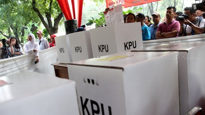 Petugas Kelompok Penyelenggara Pemungutan Suara (KPPS) memberikan pengarahan kepada warga saat simulasi pemungutan suara di Taman Suropati, Jakarta, Rabu (10/4). [Suara.com/Arief Hermawan P]