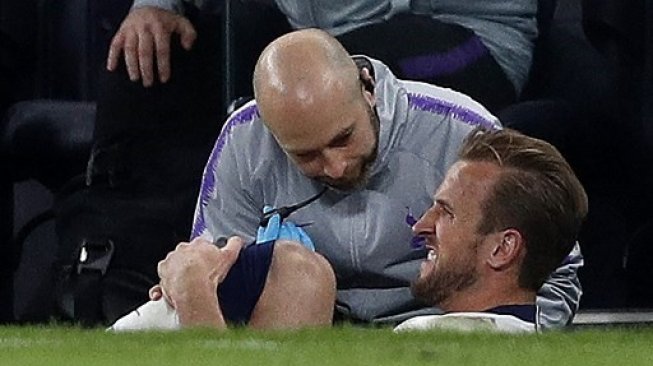 Striker Tottenham Hotspur Harry Kane (kanan) mendapatkan perawatan di pinggir lapangan setelah mendapatkan cedera saat menghadapi Manchester City di Liga Champions. Adrian DENNIS / IKIMAGES / AFP