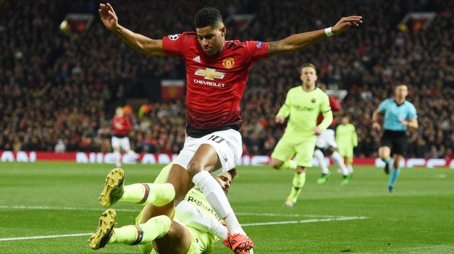 Pemain Manchester United Marcus Rashford diblokir oleh bek Barcelona Gerard Pique saat pertandingan sepak bola perempat final leg pertama Liga Champions antara Manchester United melawan Barcelona di Old Trafford, Manchester, Inggris, kamis (11/4) dini hari WIB. [Oli SCARFF / AFP]