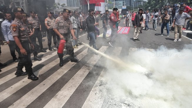 Massa yang mengatasnamakan dari Aliansi Pemuda Pengawas KPK terlibat bentrok dengan polisi saat berunjuk rasa di depan Gedung KPK, Jakarta, Kamis (11/4). [Suara.com/Muhaimin A Untung]