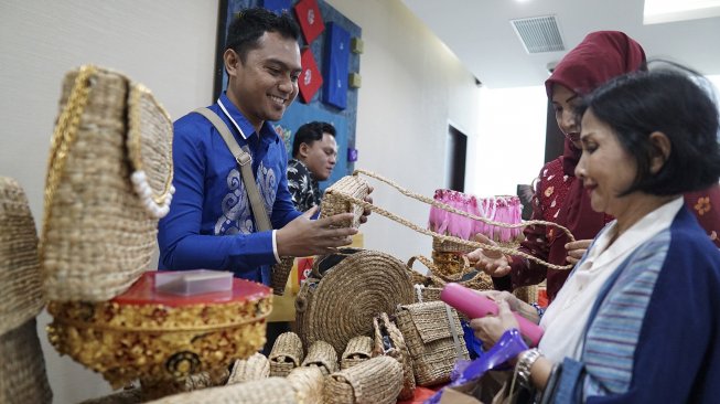 Sejumlah model menunjukkan tas berbahan dasar eceng gondok karya TiAr Handmade saat pembinaan pelaku UKM dan Dekranasda di Kantor Perwakilan (KPw) Bank Indonesia Provinsi Gorontalo, Kota Gorontalo, Gorontalo, Kamis (11/4). [ANTARA FOTO/Adiwinata Solihin]