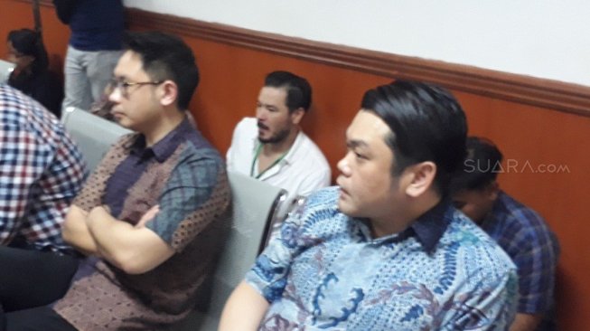 Mengenakan kemeja putih, Zack Lee duduk di lantai mengikuti sidang narkotika sahabatnya, Steve Emmanuel di PN Jakarta Barat, Kamis (11/4/2019). [Ismail/Suara.com] 