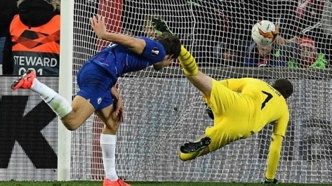 Bek Chelsea Marcos Alonso (kanan) mencetak gol lewat sundulannya ke gawang Slavia Praha dalam laga leg pertama perempat final Liga Europa. JOE KLAMAR / AFP